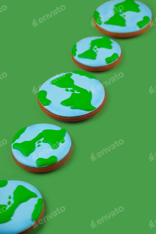 Preview: Earth Day concept. Сookies in shape of Earth on green backdrop.