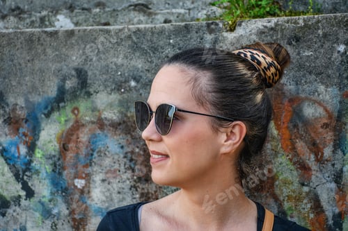 Preview: Woman Wearing Sunglasses Posing in Front of Graffiti