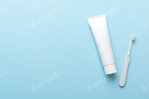 Preview: toothpaste and toothbrush top view with copy space on colored background.