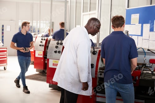 Preview: Engineer overseeing an apprentice at his workstation