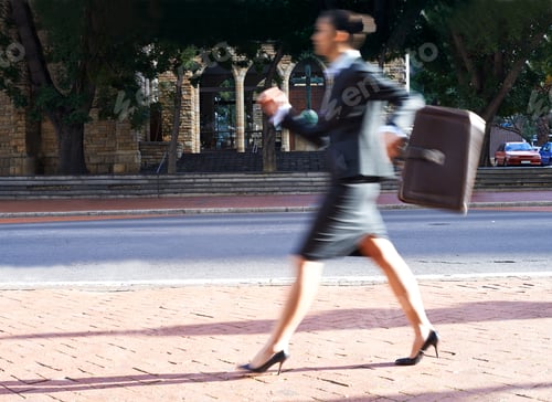 Preview: Busy busy businesswoman. Motion blurred shot of a businesswoman walking in the city.