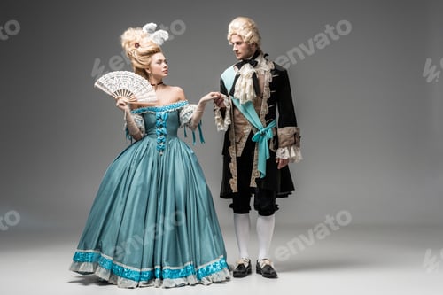 Preview: beautiful victorian woman with fan looking at gentleman in wig while holding hands on grey