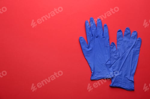 Preview: Pair of medical gloves on red background, flat lay. Space for text