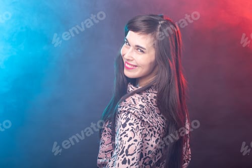 Preview: Smiling charming young brunette woman standing against a colourful background with copy space