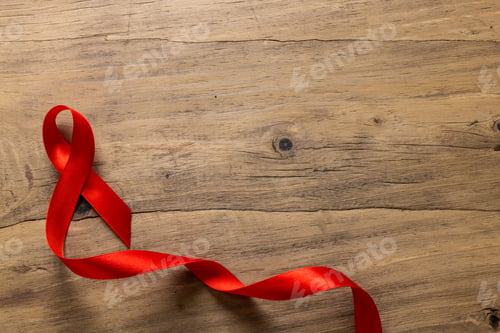 Preview: Directly above shot of single red aids awareness ribbon on wooden table, copy space