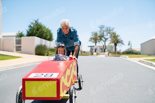 Preview: Grandfather playing with grandson on a big toy car