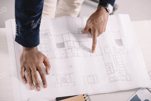 Preview: cropped view of african american architect working with blueprint