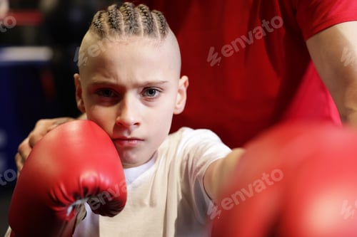 Preview: Boy in protective gloves with his boxing coach at training center