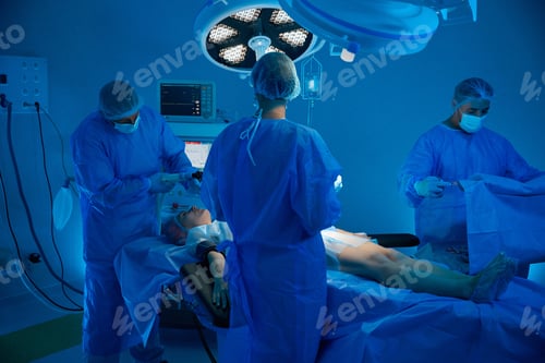 Preview: Anesthetist applying anesthesia to female patient with team of skilled surgeons