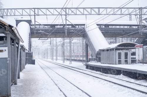 Preview: Snow covers the railway station creating a winter wonderland with empty tracks and falling flakes in
