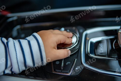 Preview: Child hand touch multimedia system lever in modern car