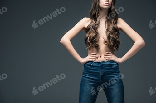 Preview: cropped view of half naked girl with long hair standing in akimbo position, isolated on grey