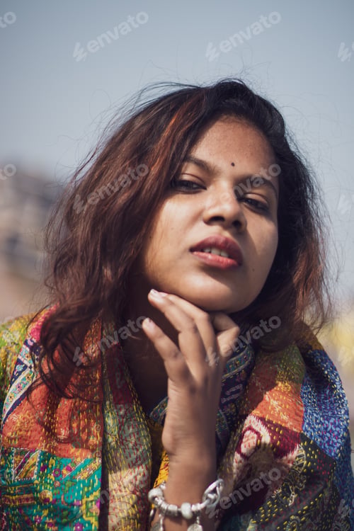 Preview: Vertical shot of an attractive woman with a scarf on a blurred background