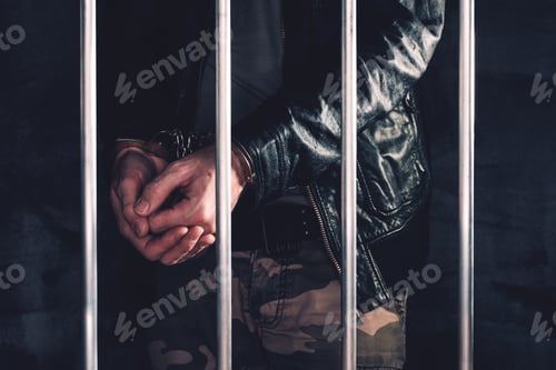 Preview: Handcuffed man behind prison bars