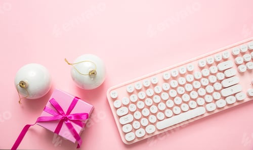 Preview: Christmas balls, gift and computer keyboard against pink background