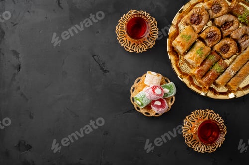 Preview: Turkish tea in traditional glasses baklava on black background