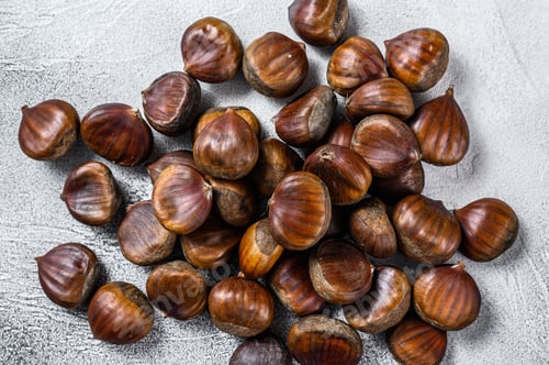 Preview: Raw chestnuts on a wooden table. White background. Top view