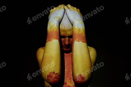 Preview: Man Holding Head Standing in Projector Light Displaying Nuclear Explosion against Black