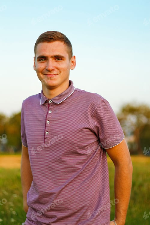 Preview: Happy people. Portrait of serious young brunette man in purple polo shirt standing outdoor on nature