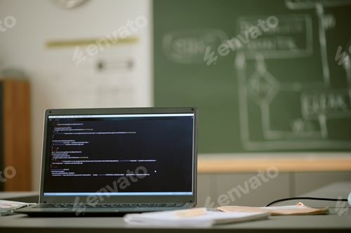 Preview: Laptop Displaying Programming Code in Classroom with Chalkboard in Background