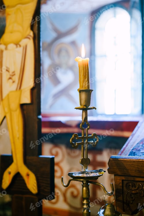 Preview: Wax candle on a candlestick near the crucifix in the temple