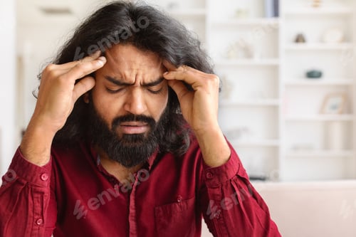 Preview: Closeup of exhausted indian man suffering from headache