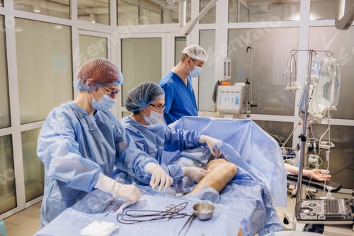 Preview: Team surgeon in uniform perform varicose veins correction operation on a patient at surgery clinic