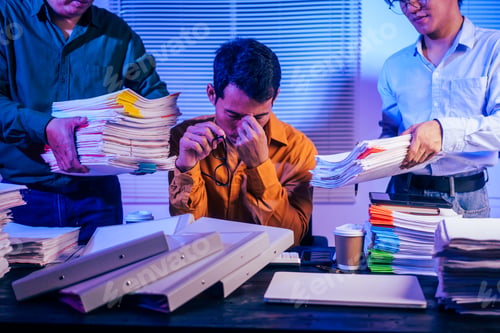 Preview: Three young businessmen work together on laptops in the office at night. They are stressed tired