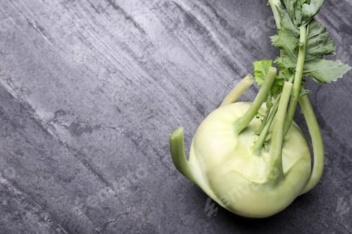 Preview: Whole ripe kohlrabi plant on grey table, top view. Space for text