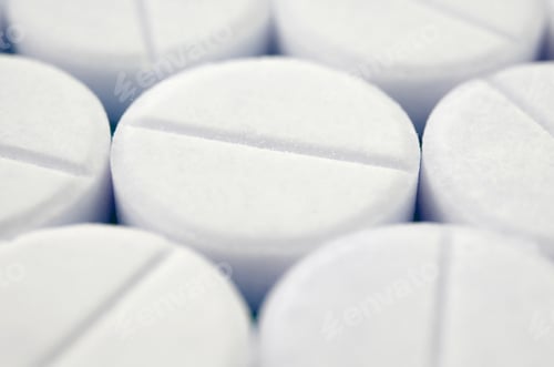 Preview: Close-up image of white pills. Macro with extremely shallow depth of field