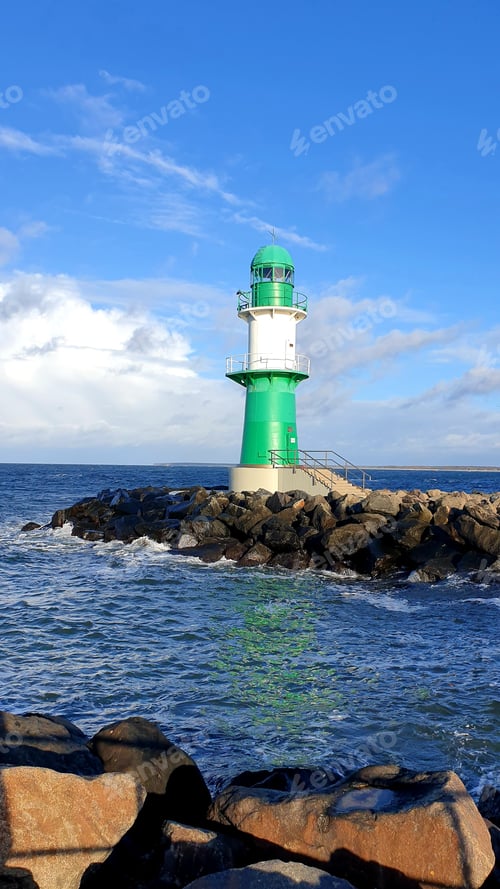 Preview: Green with a white stripe operating lighthouse somewhere near the coast of the sea