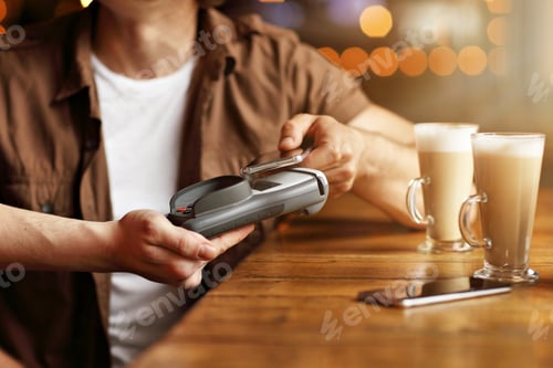 Preview: Cute couple on a date at the cafe paying by credit card