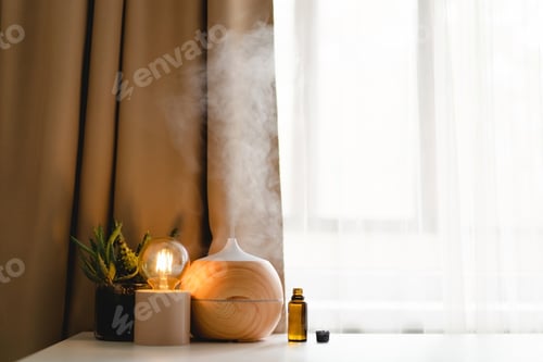 Preview: Aromatherapy concept. Aroma oil diffuser on the table against the window.