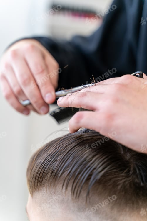 Preview: The hairdresser makes a boy's haircut with a clipper