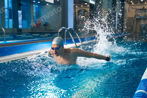 Preview: Strong man swimming in pool during workout