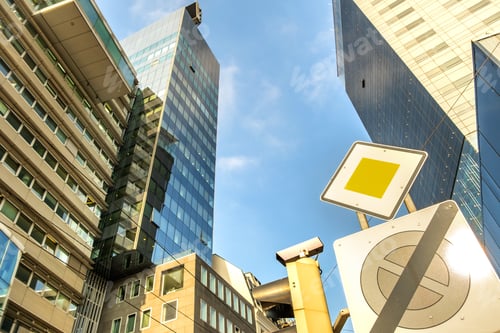 Preview: Perspective view of modern high-rise glass skyscraper building and main road traffic sign