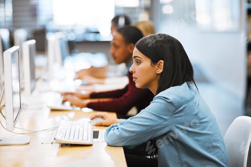 Preview: Shot of a group of university students working on computers in the library at campus