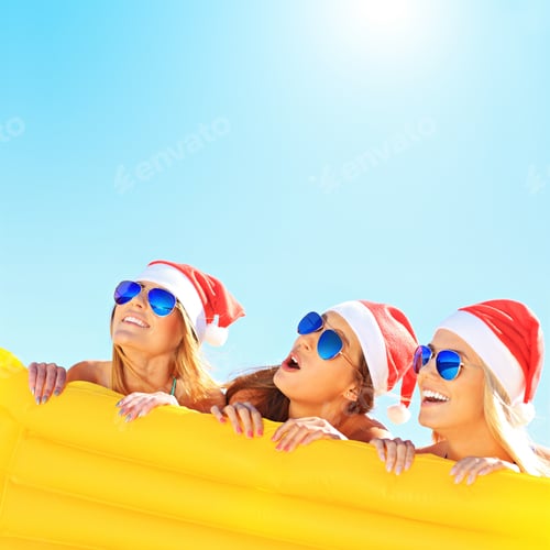 Preview: Group of girls in Santa's hats having fun on the beach