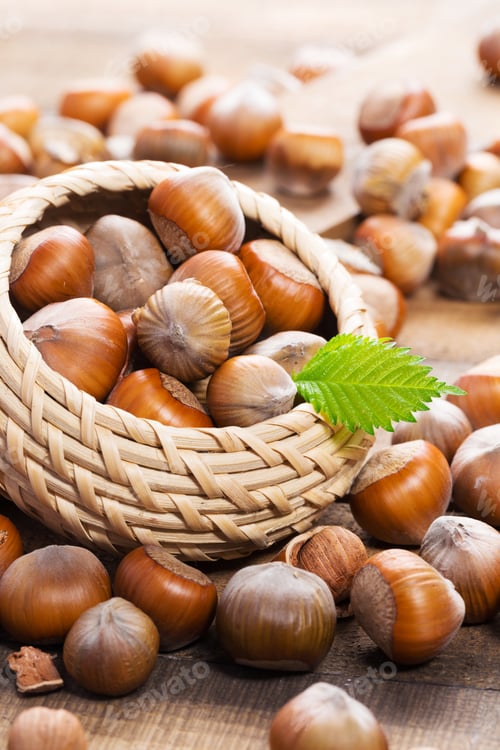 Preview: Bountiful harvest of hazelnuts in a woven basket on wooden surface