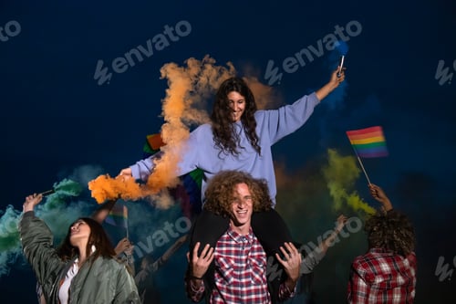 Preview: Happy group of people dancing and celebrating LGTB rights want rainbow flag in coloured smoke.