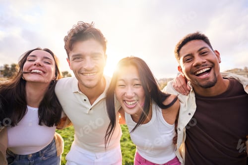 Preview: Group of multirracial people smiling at camera outside. Cheerful community of university students.