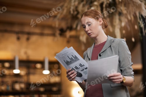 Preview: Businesswoman reading financial documents