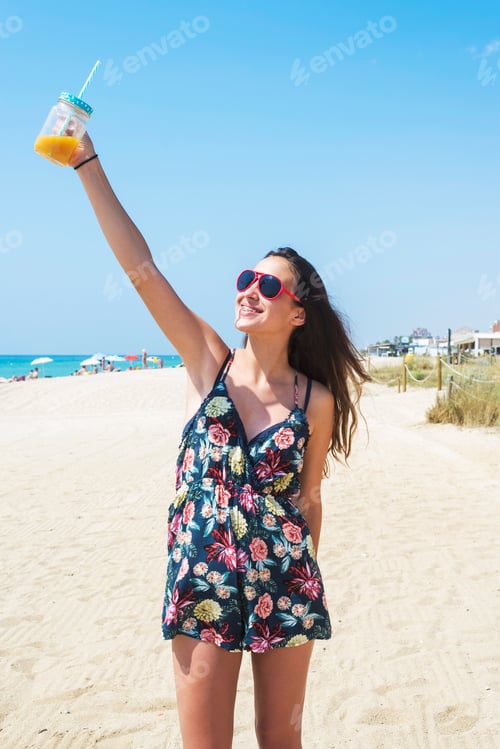 Preview: girl came to the resort, wears a fashionable dress and sunglasses, holds a delicious juice drink