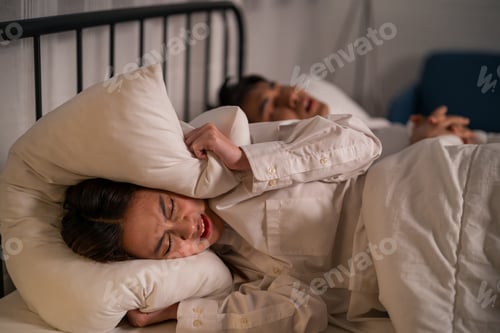 Preview: Asian woman feel frustrated from husband snoring while sleep at night.