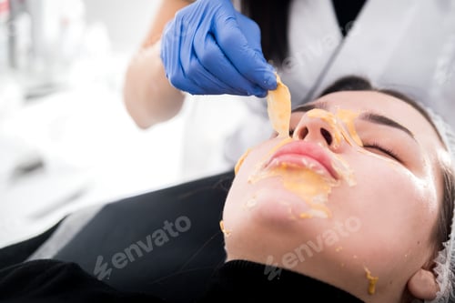 Preview: Beautician removing facial mask at cosmetic clinic, cosmetology treatment skincare face
