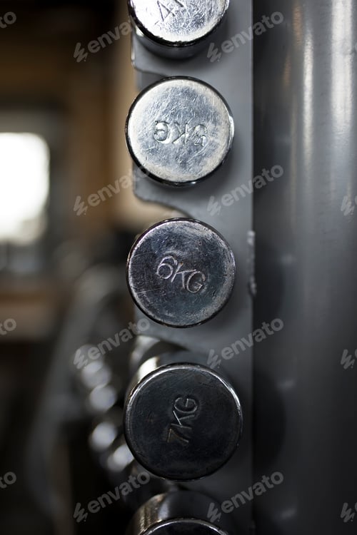 Preview: Row of metal dumbbells on rack in the gym