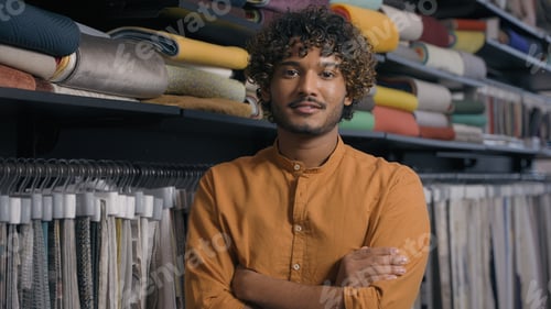 Preview: Happy smiling Arabian Indian man buyer customer in fabric shop atelier with samples of tissue