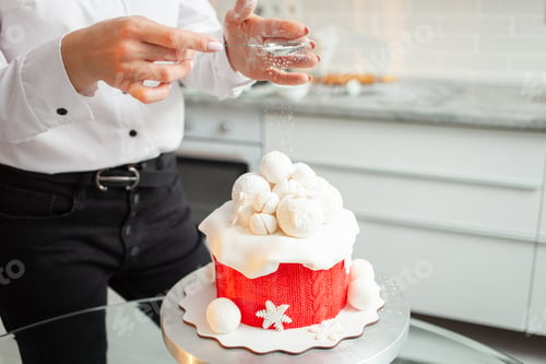 Preview: pastry chef decorates cake with powder, snow. Beautiful cake for Christmas, New Year, holiday. Home
