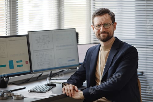 Preview: Bearded male engineer at workplace in office looking at camera smiling