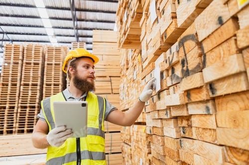 Preview: Worker Man with a bearded wearing safety uniform yellow hard hat using tablet